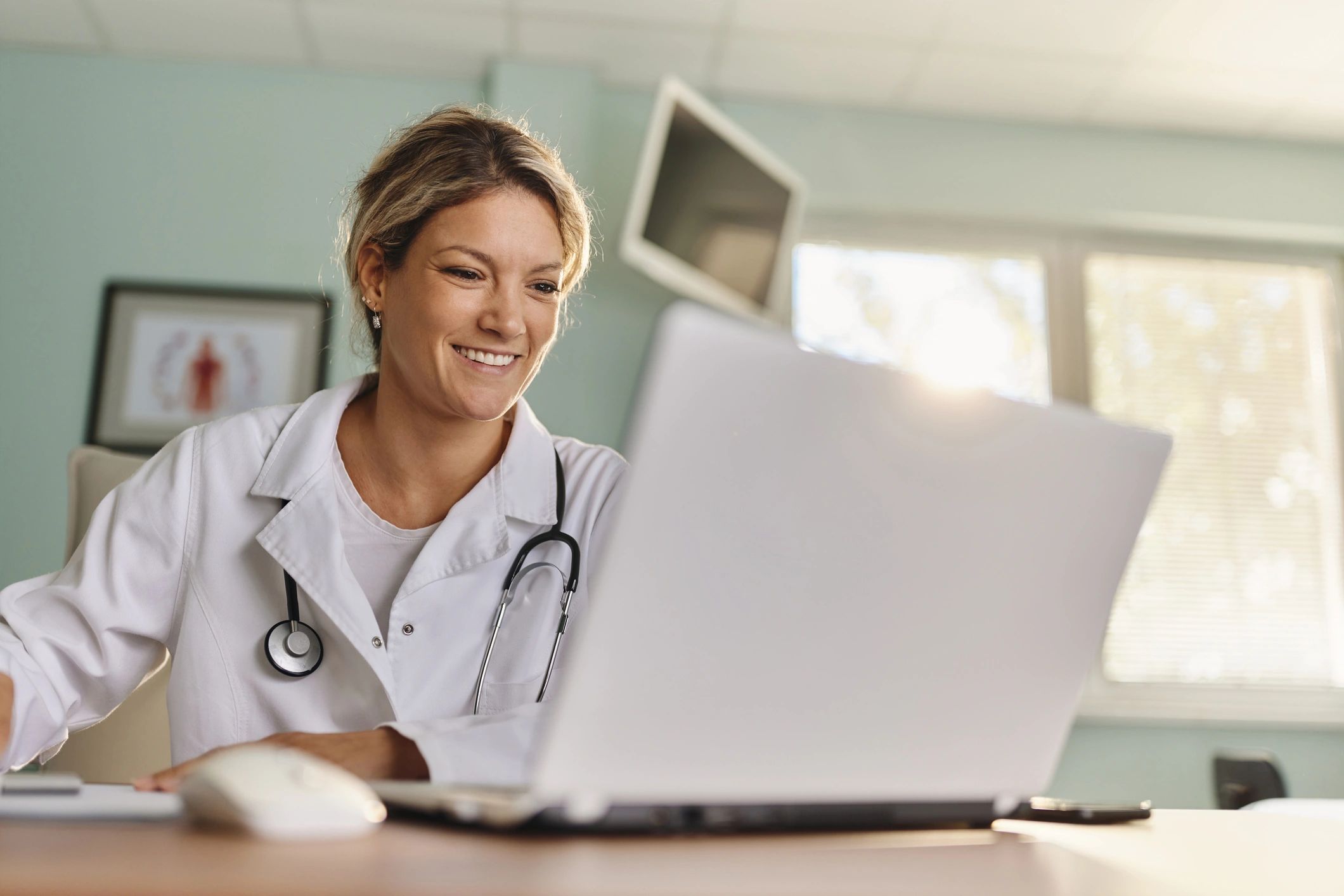 Doctor using a laptop for telehealth visit documentation