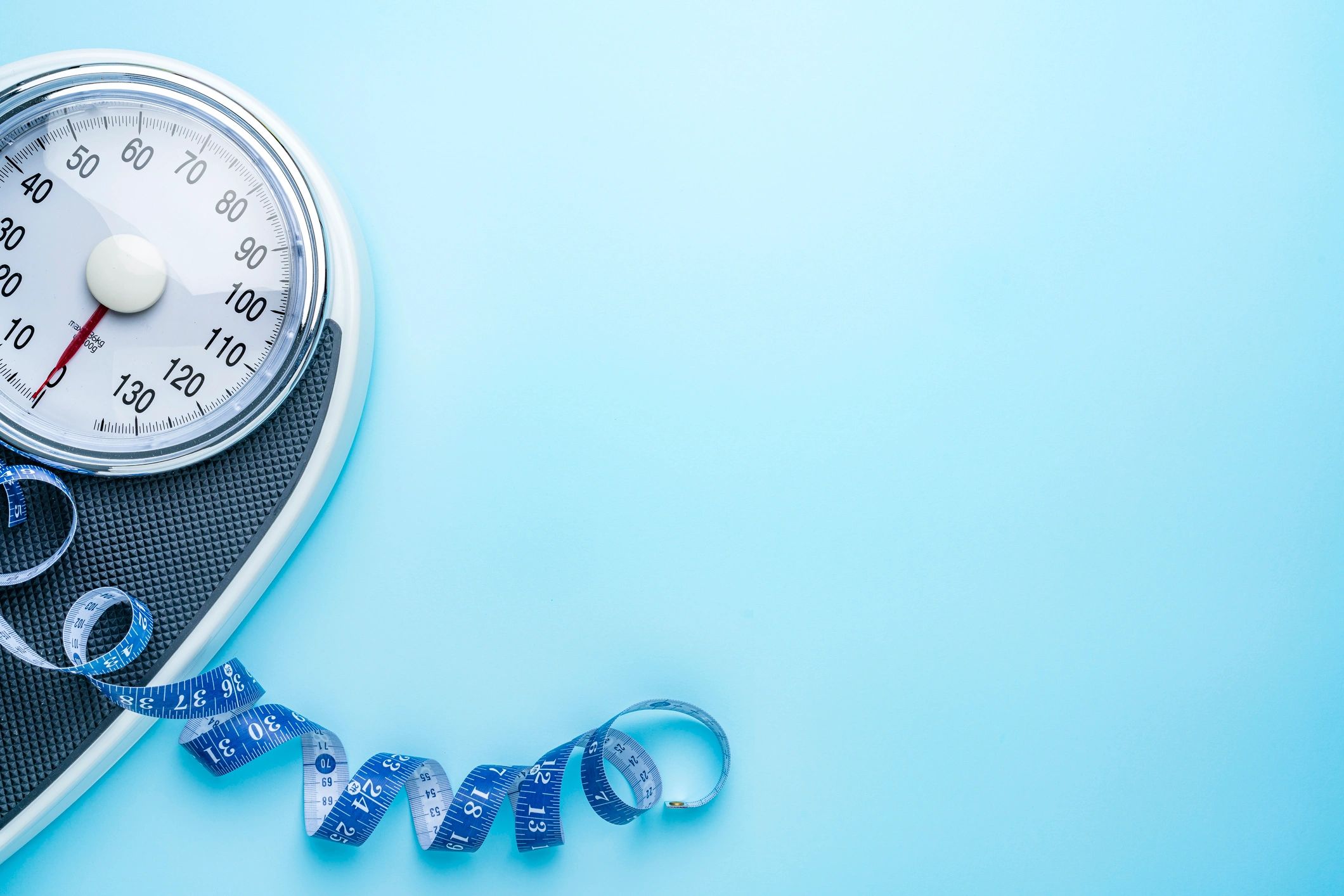 Scale and measuring tape representing weight management